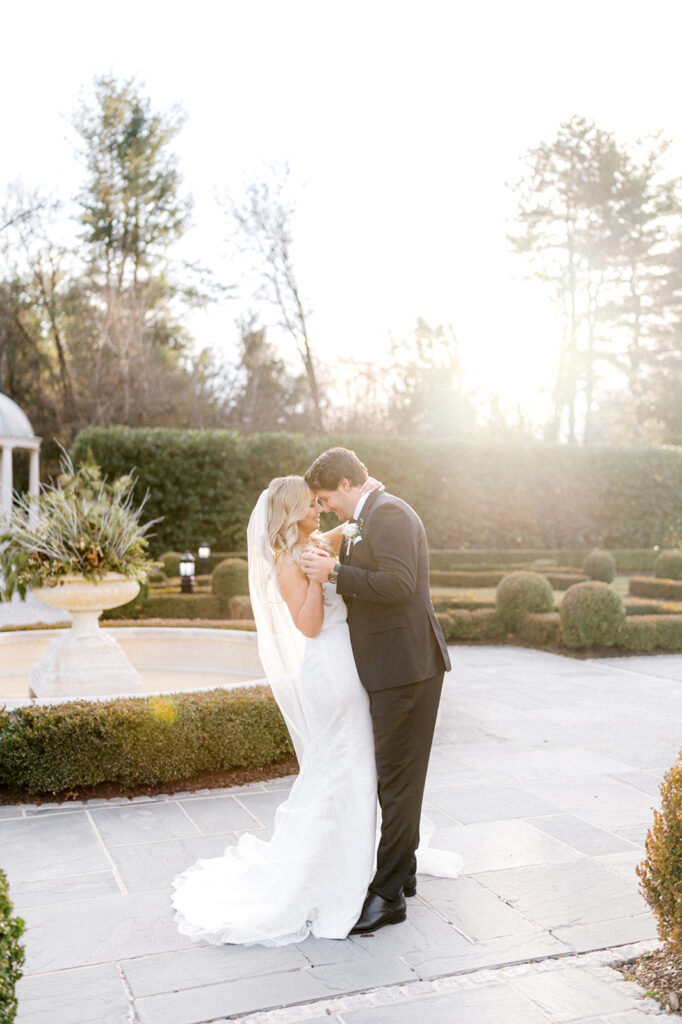 Bride and groom pose during golden hour in the gardens at French style Park Chateau wedding venue  in New Jersey | Photo by Lindsey Ford Photography