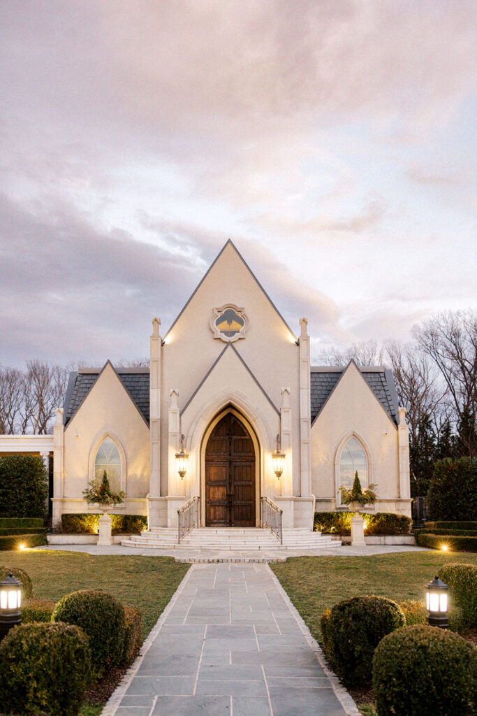 Exterior photo of the ceremony chapel and gardens at dusk at French style Park Chateau wedding venue in New Jersey | Photo by Lindsey Ford Photography