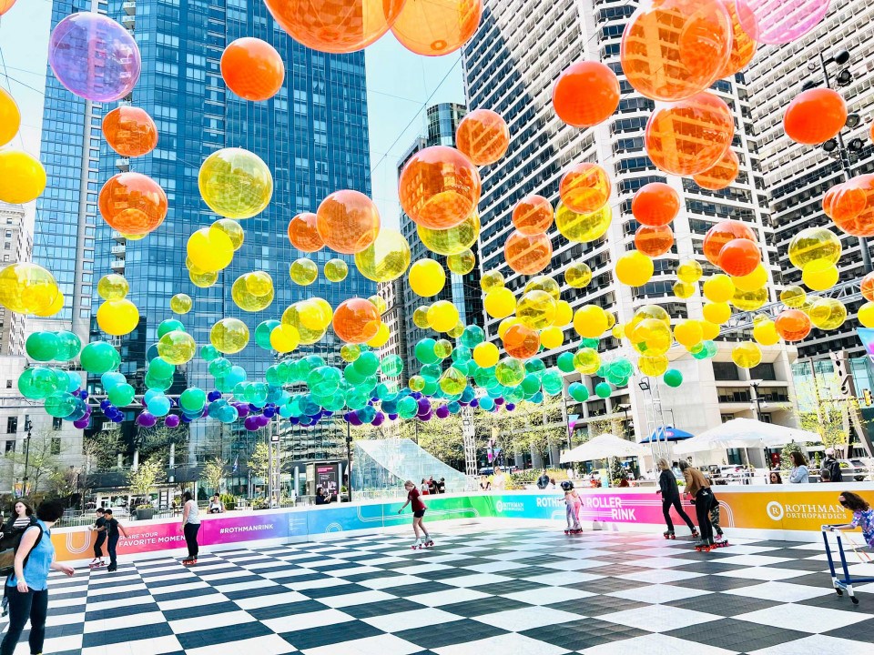 Dilworth Park Roller Skating Rink in Philadelphia is decorated with brightly colored beach balls strung in mid air