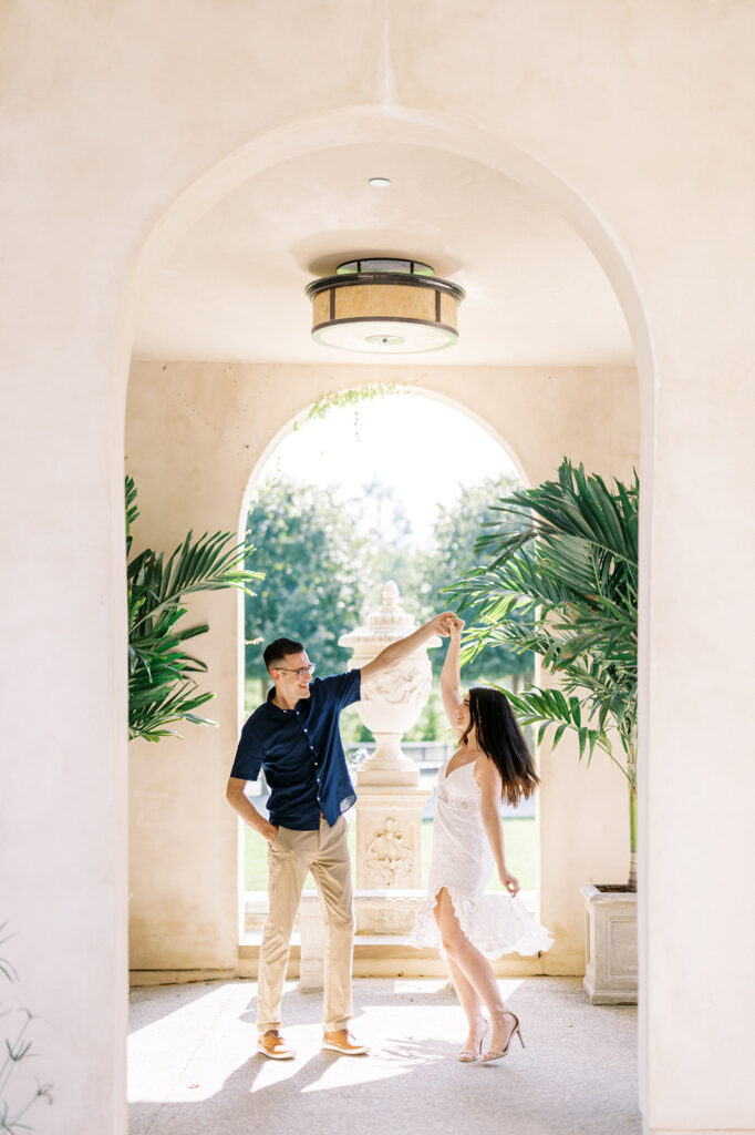 Couple danced under stucco archway at Longwood Gardens | Longwood Gardens Engagement Photo Session in Philadelphia by Lindsey Ford Photography