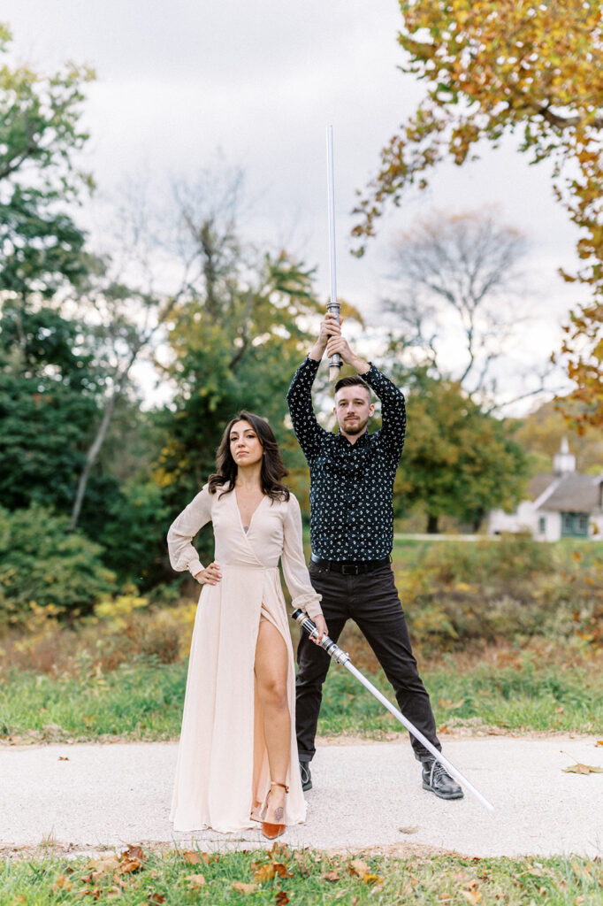 Couple poses with light sabers in Valley Forge | Valley Forge Engagement Session by Lindsey Ford Photography