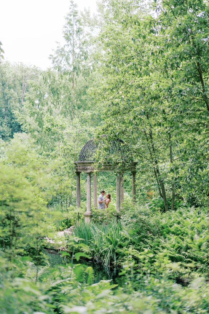Couple poses under pergola at Longwood Gardens | Longwood Gardens Engagement Photo Session by Lindsey Ford Photography