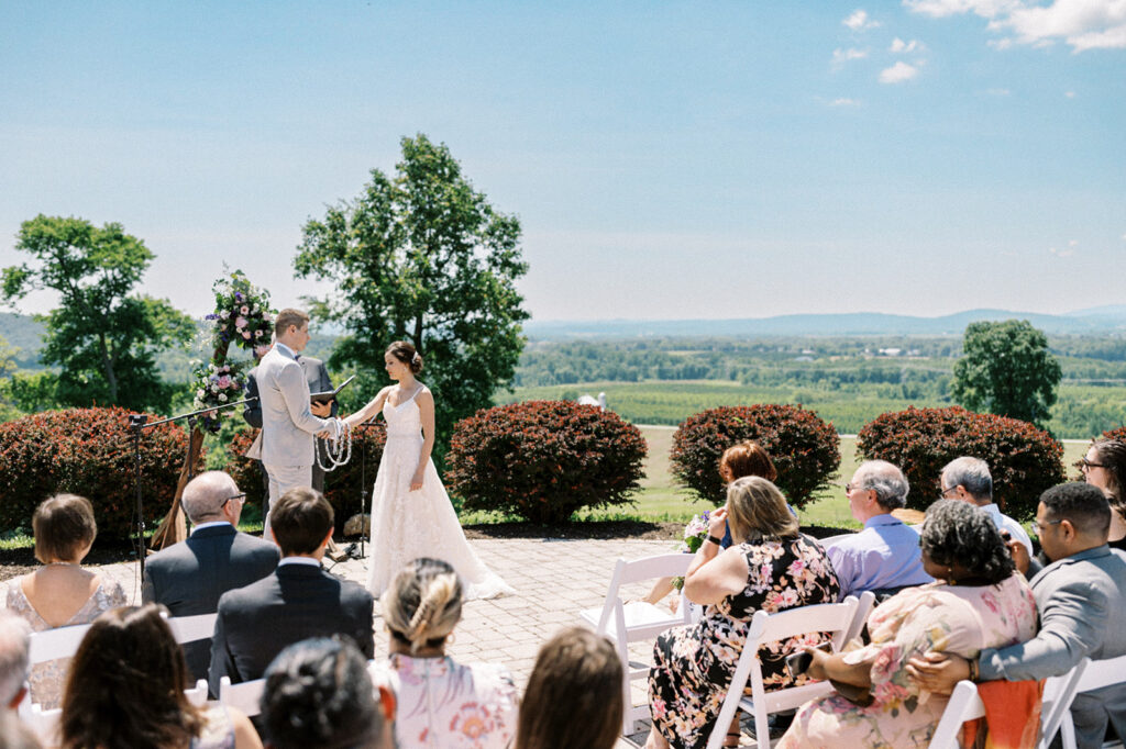 Bride and groom exchange vows during an intimate microwedding at Hauser Hill on a hilltop that overlooks vineyards and farmland | 2024 Wedding trends by Lindsey Ford Photography