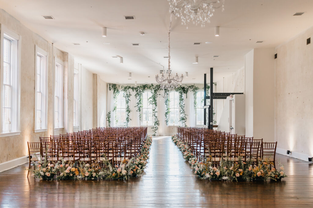 Large ceremony space is decorated with fall florals and greenery for a November wedding ceremony at Excelsior in Lancaster PA
