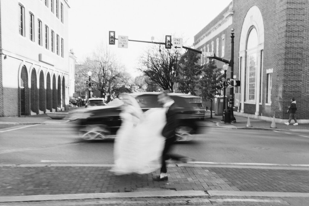 Blurred black and white photo of bride and groom running through the streets of downtown Lancaster