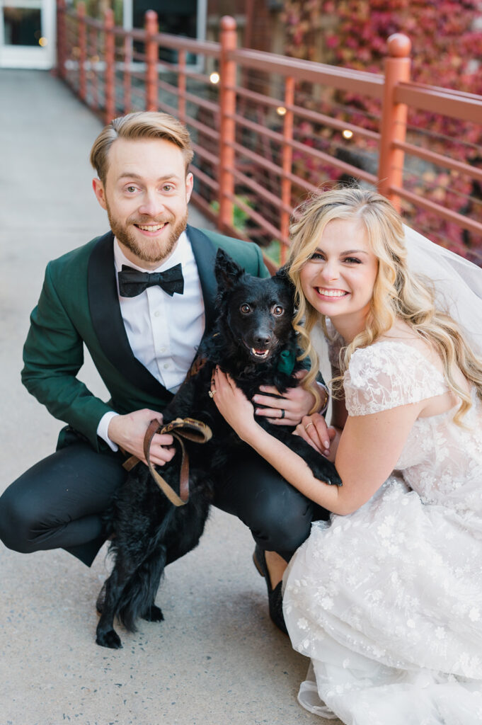 Bride and groom pose with their black Mudi dog outside of Excelsior wedding venue in downtown Lancaster PA