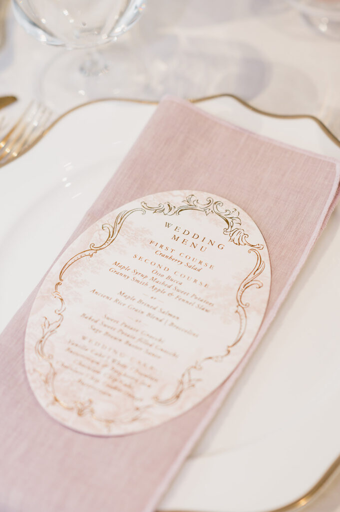 Close up photo of a dinner menu sitting on a pink linen napkin