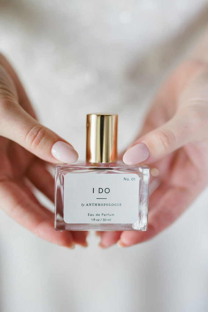 Close up photo of bride holding bottle of I Do perfume from Anthropologie at her Terrain wedding in Devon PA