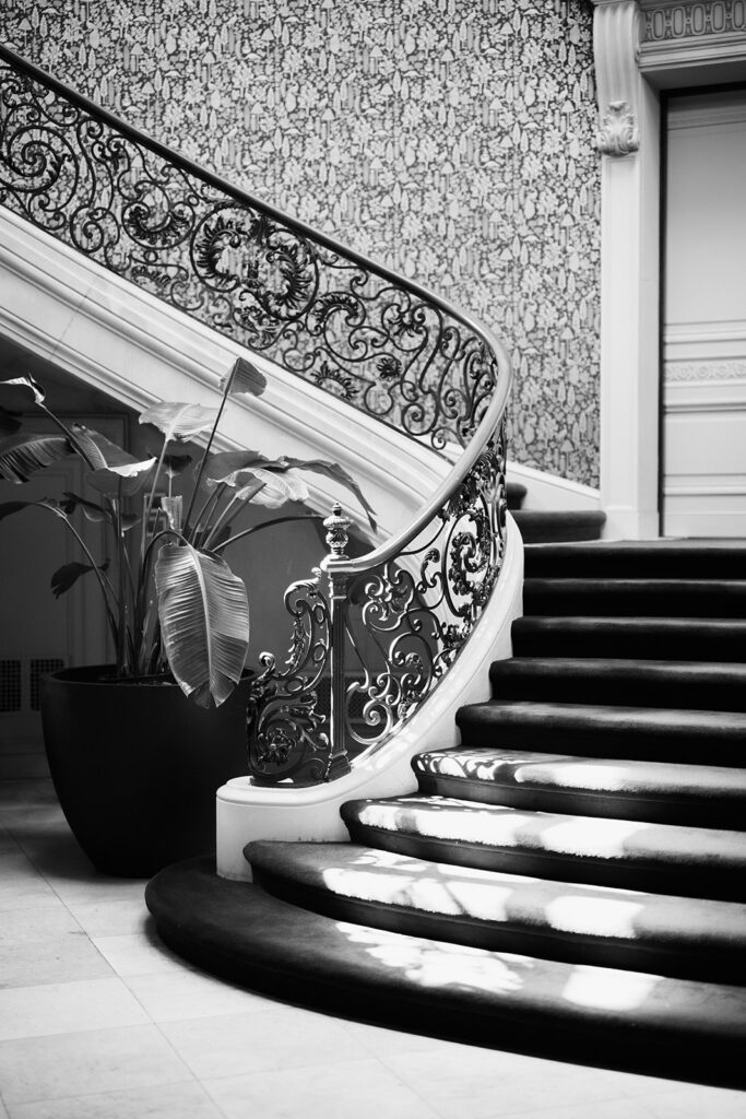 Black and white photo of grand staircase with wrought iron banister at Elkins Estate in PA