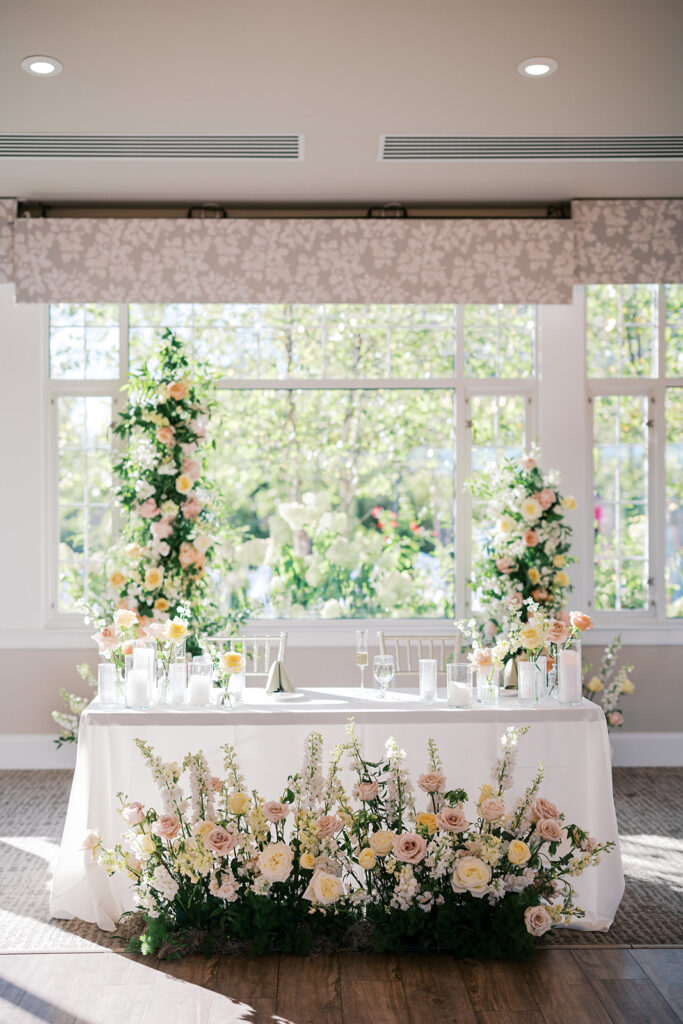 Sweetheart table is surrounded with pastel pink, yellow, and white flowers at The Gardens at Applecross | Lindsey Ford Photography