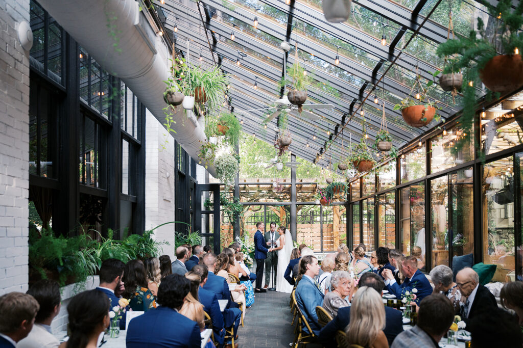 Wedding ceremony takes places inside a patio greenhouse off of Osteria Italian restaurant in Philadelphia