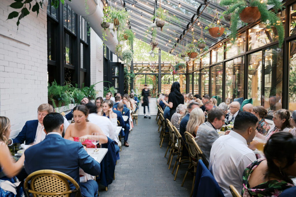 Wait staff scurries through the Osteria outdoor patio filled with wedding guests