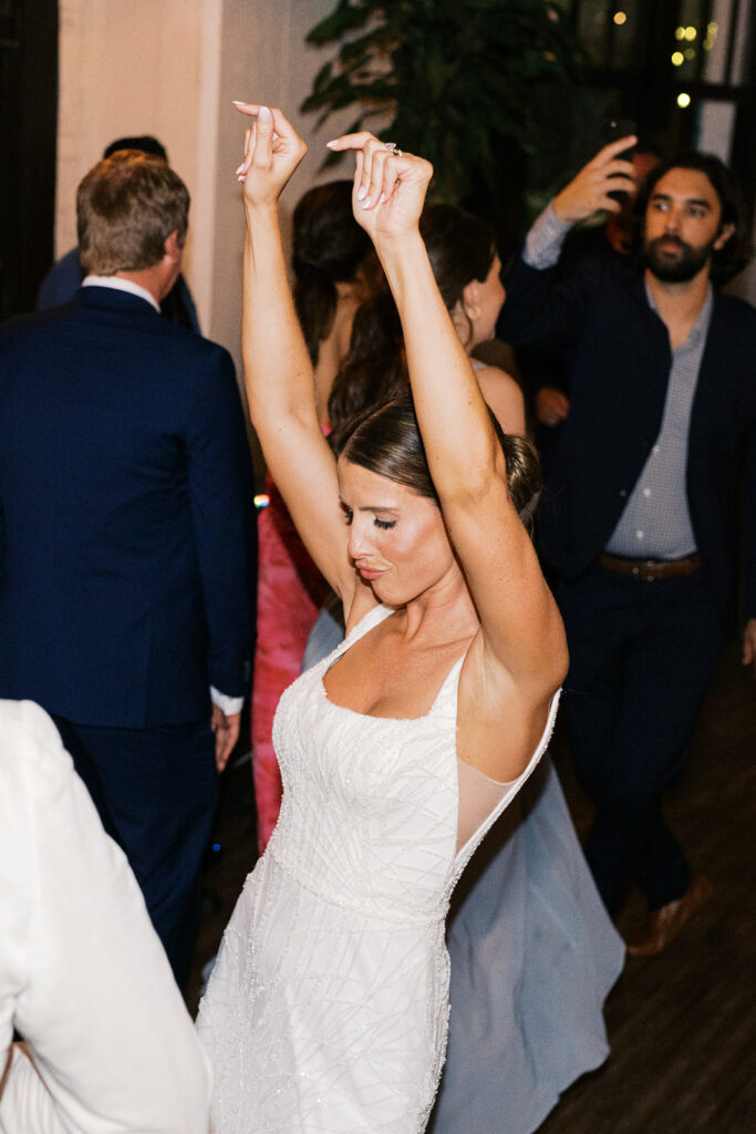 Bride dances with her eyes shut and her hands in the air at Osteria in Philly