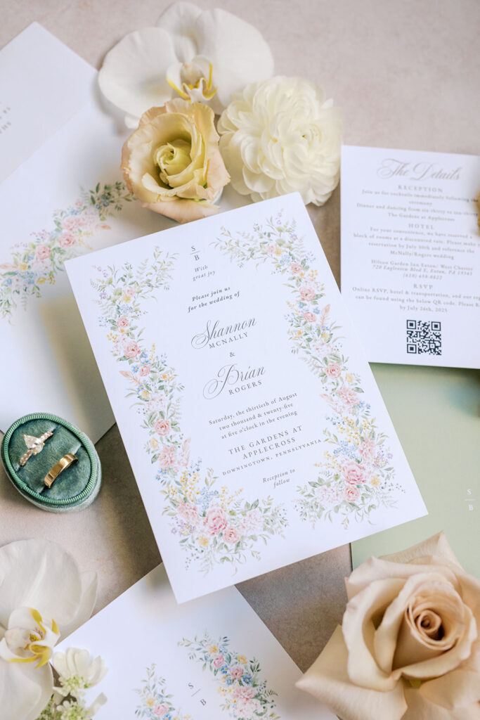 Wedding invitation suite with a pastel floral design surrounded by loose florals