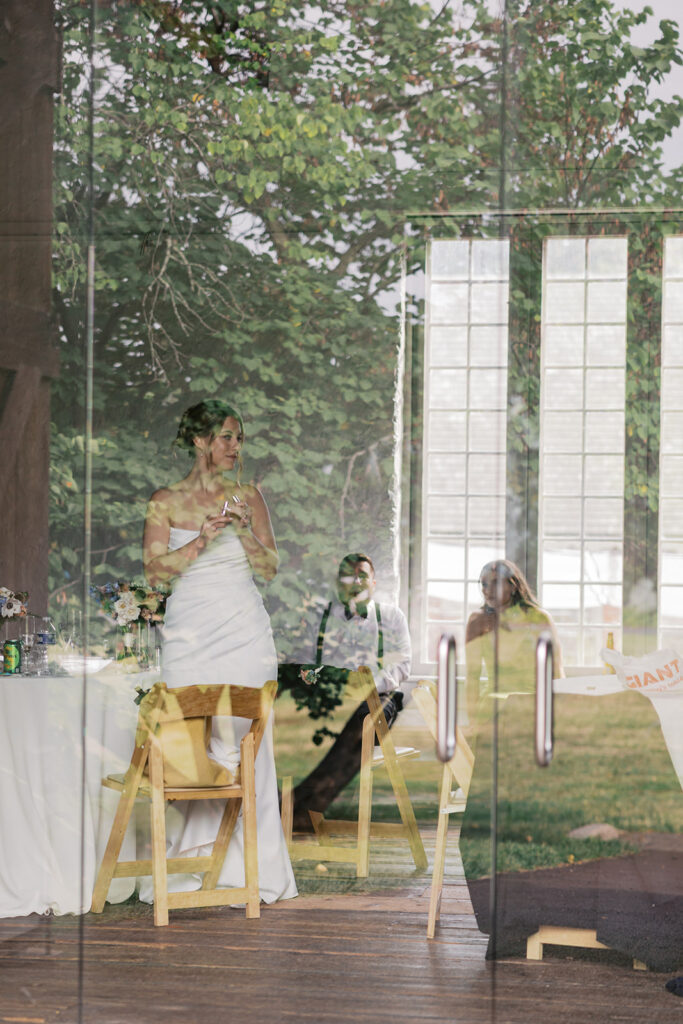 Photo of bride through glass panel wall