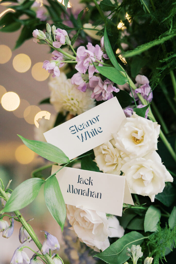 Two placecards in retro font read "Eleanor White" and "Jack Monahan"