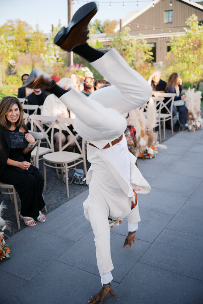 Groom does a handspring down the aisle of his wedding ceremony at Terrain Gardens at DelVal