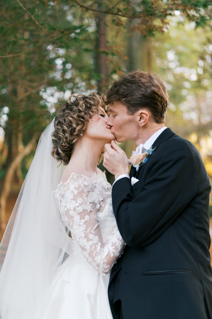 Bride and groom kiss during their first look photos at the Stoneleigh Gardens in Villanova PA
