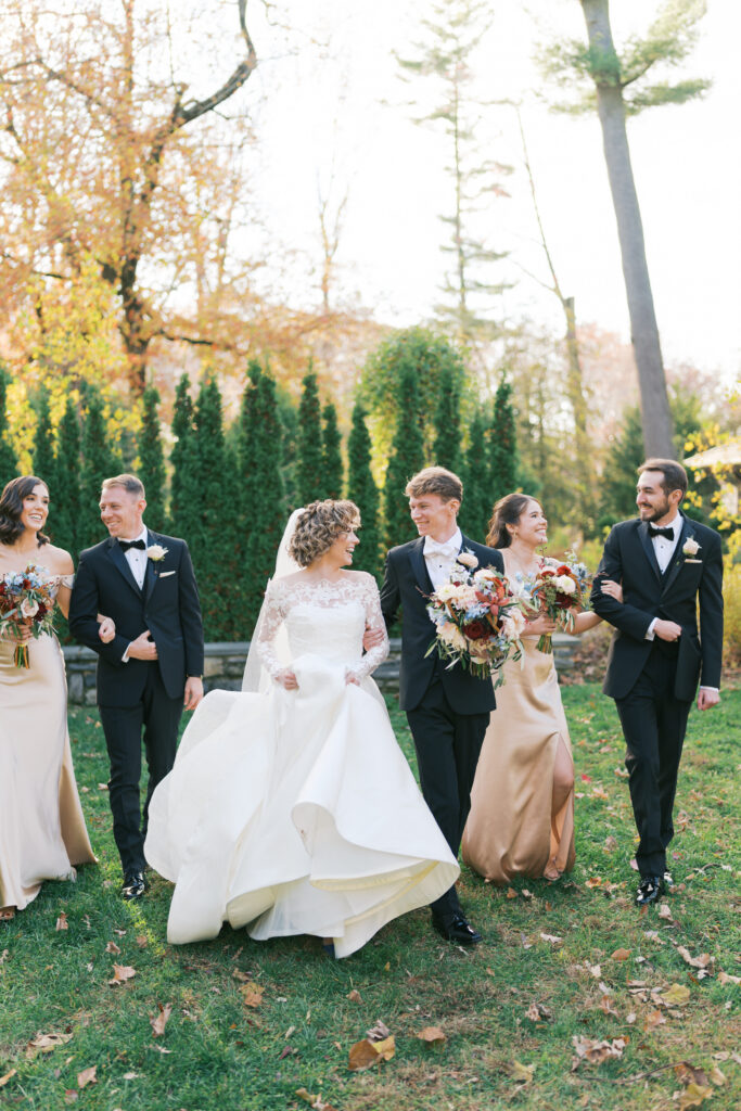 Bride and groom walk alongside their small wedding party at the Stoneleigh Gardens