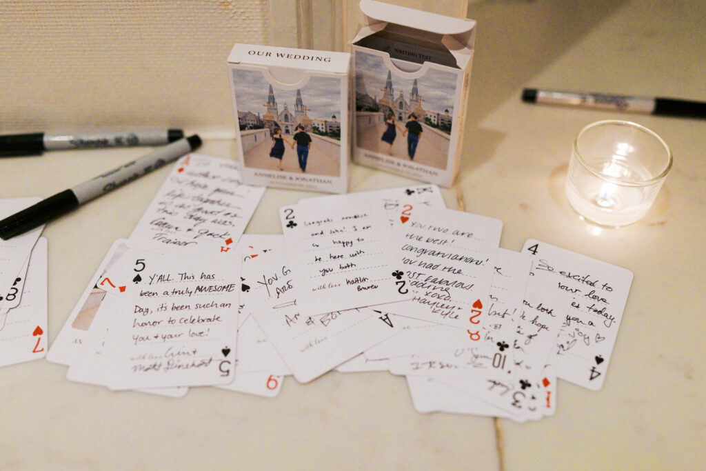 Notes to the bride and groom written by guests on playing card design stationary at The Ballroom at Ellis Preserve