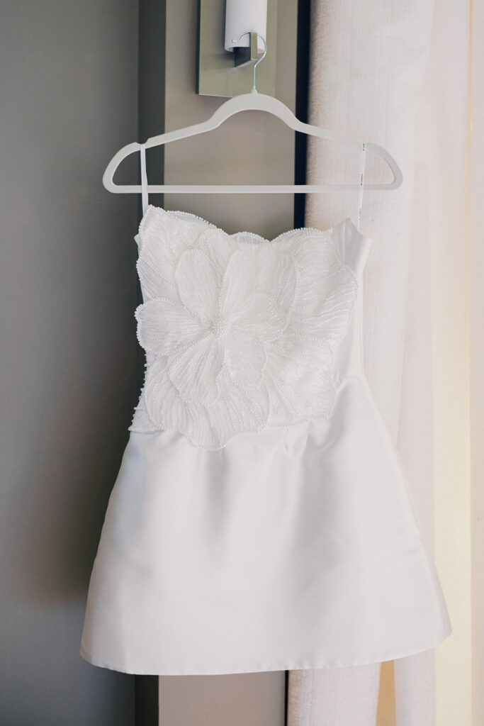 White beaded short reception dress hanging on white hanger Lake House Inn wedding Pennsylvania