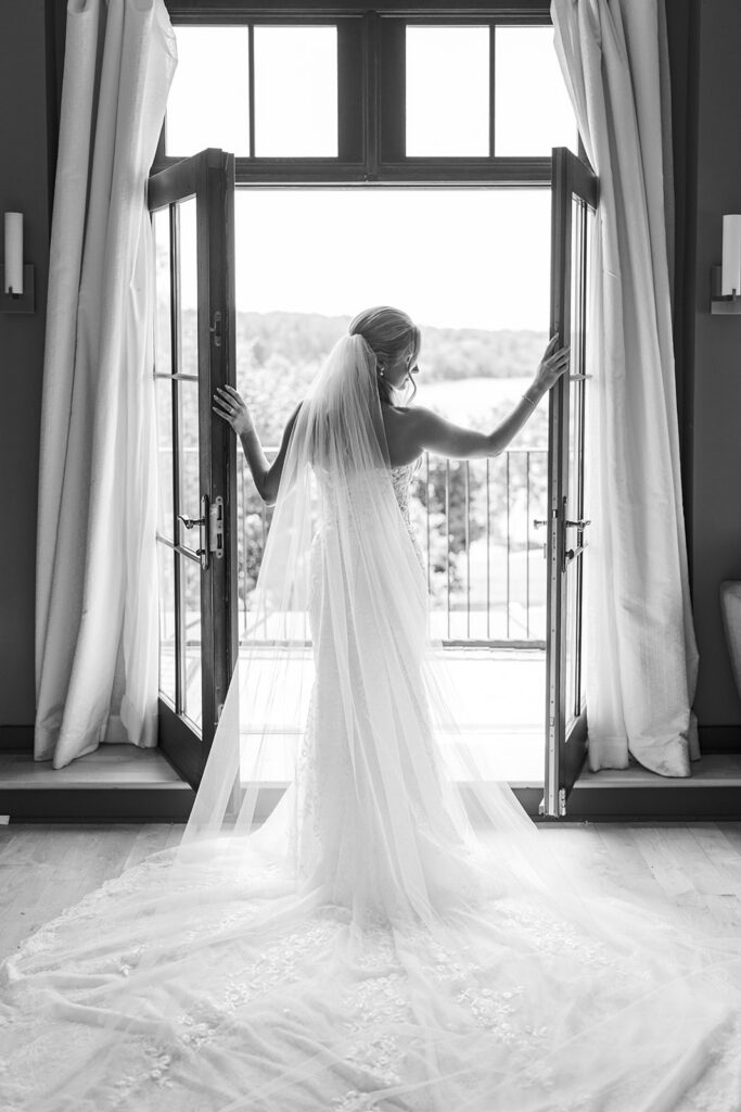 Elegant bridal portrait in window with veil dramatic natural light Lake House Inn Pennsylvania