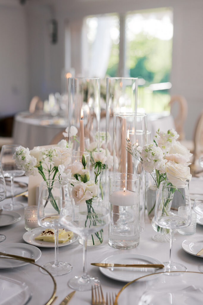 Modern monochromatic white wedding tablescape with floating candles and delicate floral arrangements Lake House Inn