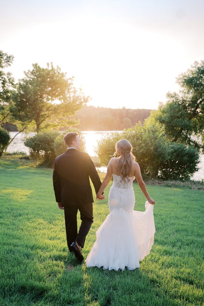 Romantic couple walking toward lake at golden hour sunset Lake House Inn unique wedding photo ideas Pennsylvania