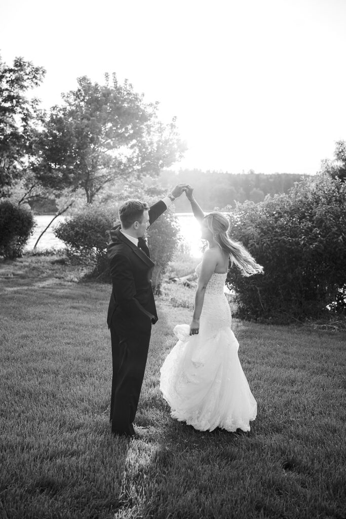 Elegant black and white bride twirl portrait with lakefront backdrop nontraditional wedding pictures Lake House Inn