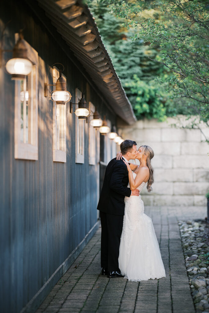 Romantic couple kiss Lake House Inn exterior with vintage string lights architectural detail Pennsylvania wedding venue