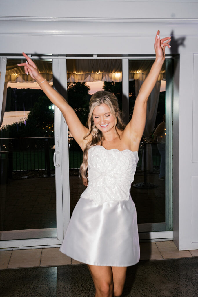 Joyful bride dancing in white short reception dress Lake House Inn evening celebration Pennsylvania wedding