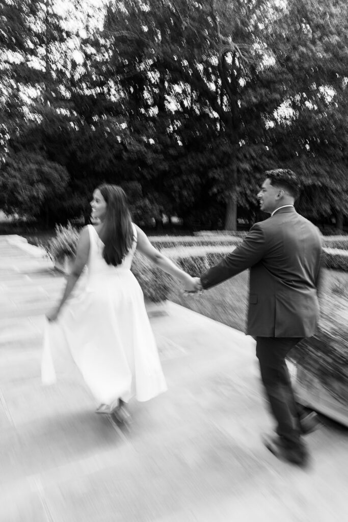 Nemours Estate engagement photos black and white motion blur couple running hand in hand along Nemours balustrade terrace Wilmington Delaware