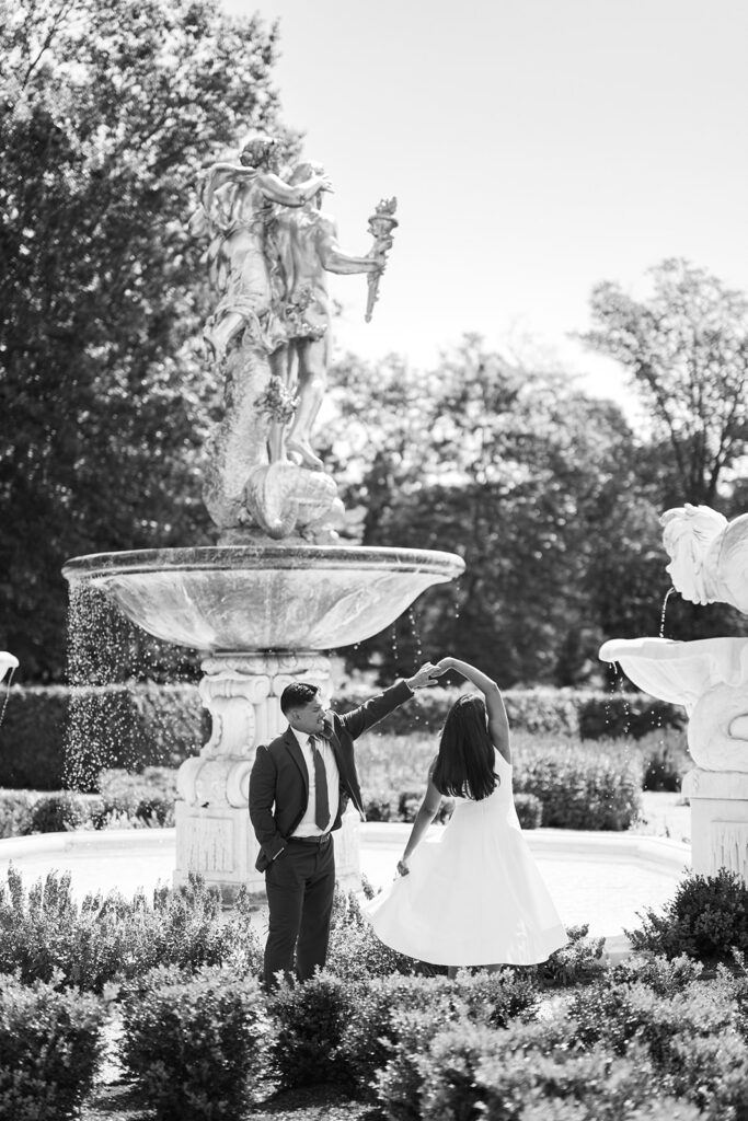 Nemours Estate engagement session black and white couple spinning at Neptune fountain formal garden Wilmington Delaware engagement photo ideas