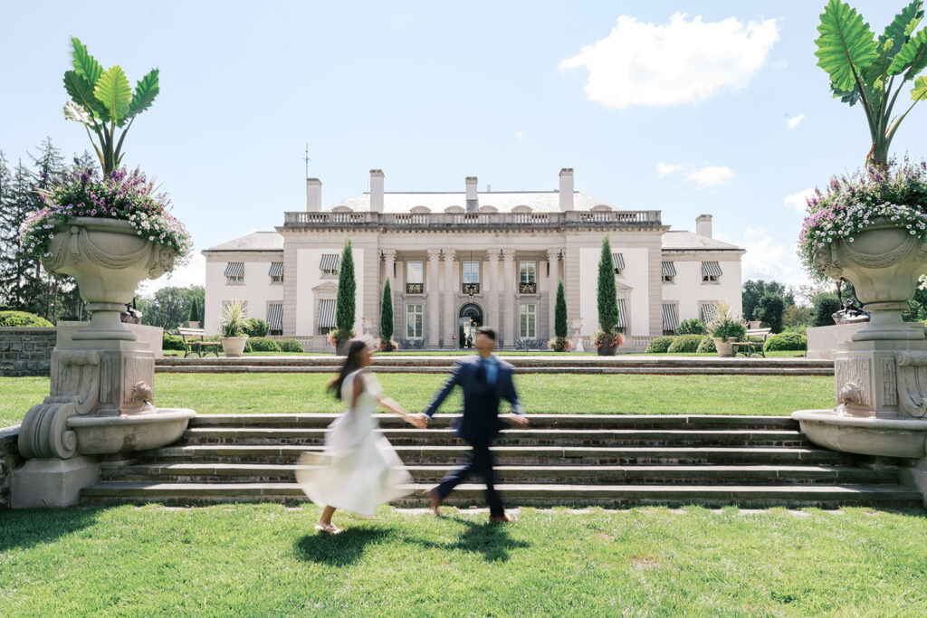 Nemours Estate engagement session motion blur couple running holding hands in white flowing dress and navy suit in front of Nemours mansion Wilmington Delaware