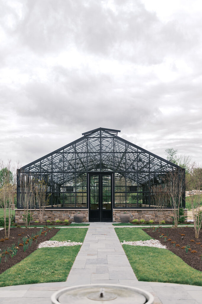 Exterior of the glass greenhouse wedding venue and garden path at Westwynd Gardens in Honey Brook, PA