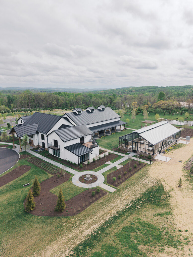 Aerial drone view of the Westwynd Gardens venue and glass greenhouse across 26 acres in Honey Brook, PA